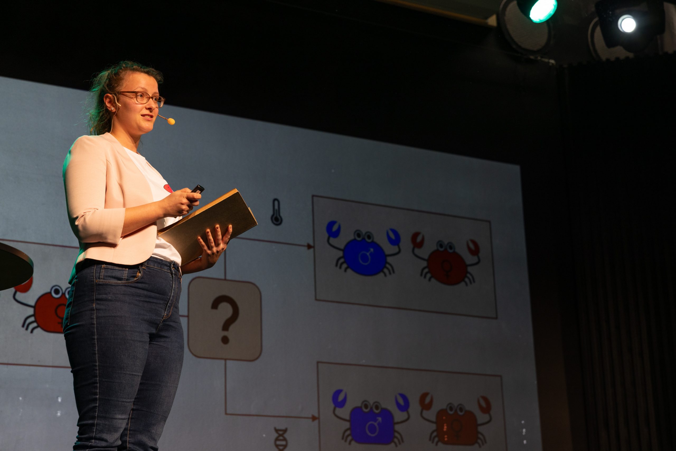 Annika während ihres Vortrages auf der Bühne mit Präsentation im Hintergrund