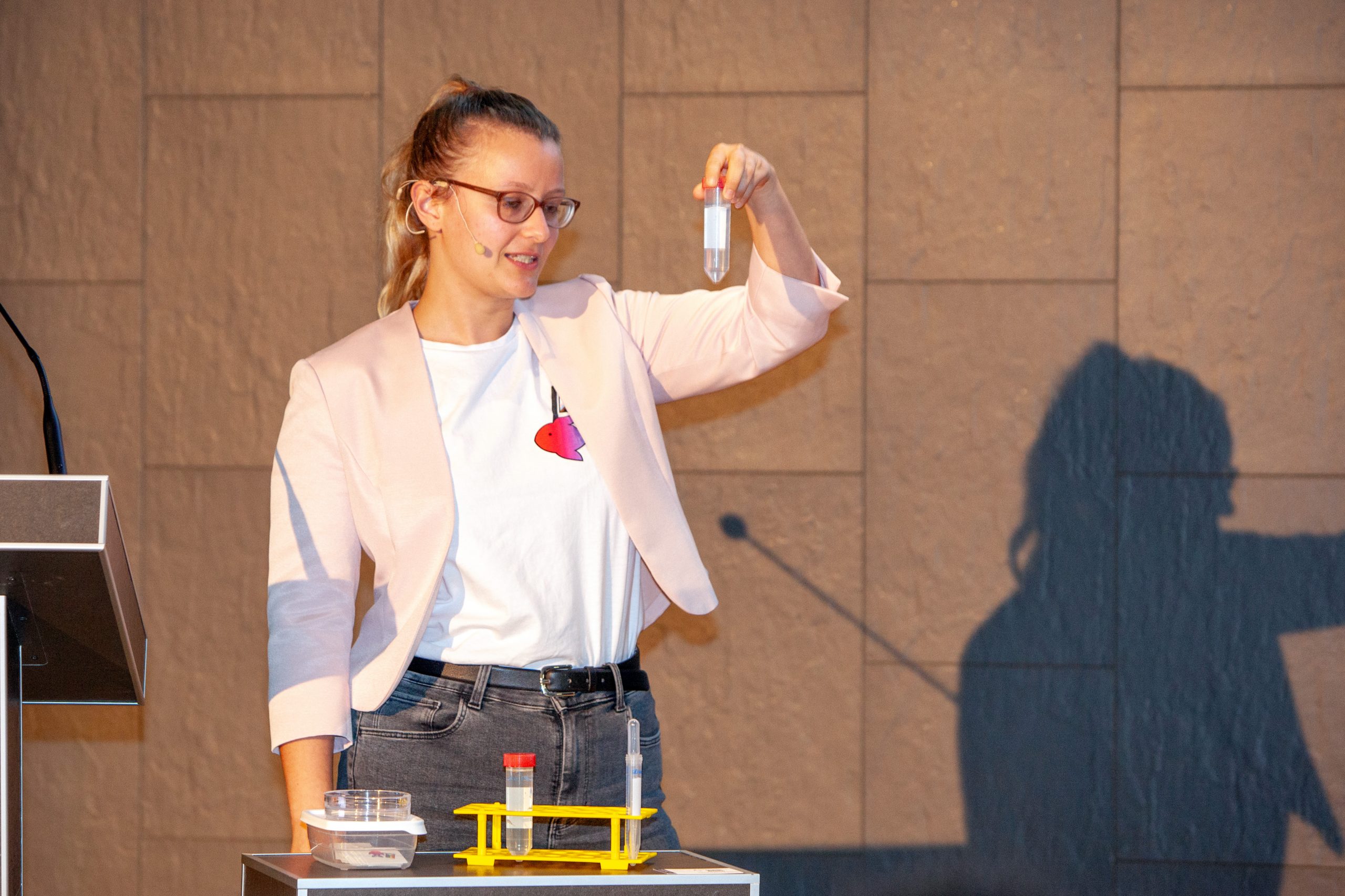 Annika hält ein Röhrchen während ihres Vortrages hoch.